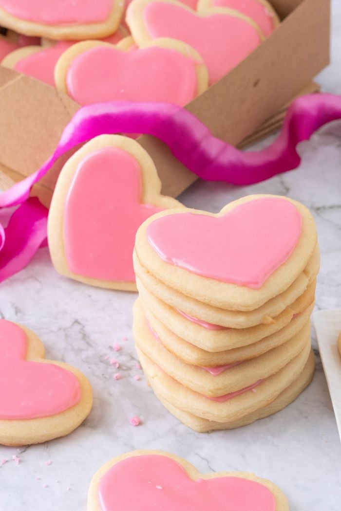 a stack of heart shaped sugar cookies with pink frosting